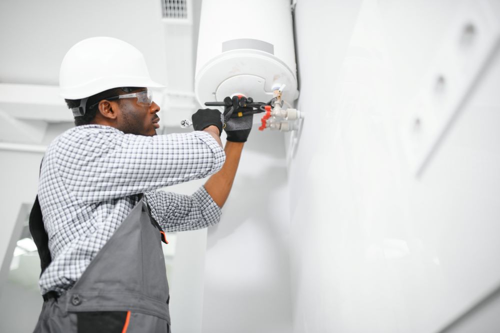 Young African Male Plumber Repairing Water Heater