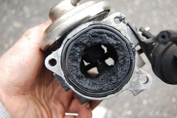 Close-up of a generator part with visible signs of carbon buildup